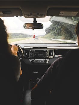 View from inside a car showing passengers looking out at an open highway, emphasizing travel and journey.