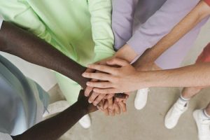 Top view of diverse hands stacked together, symbolizing unity and teamwork.